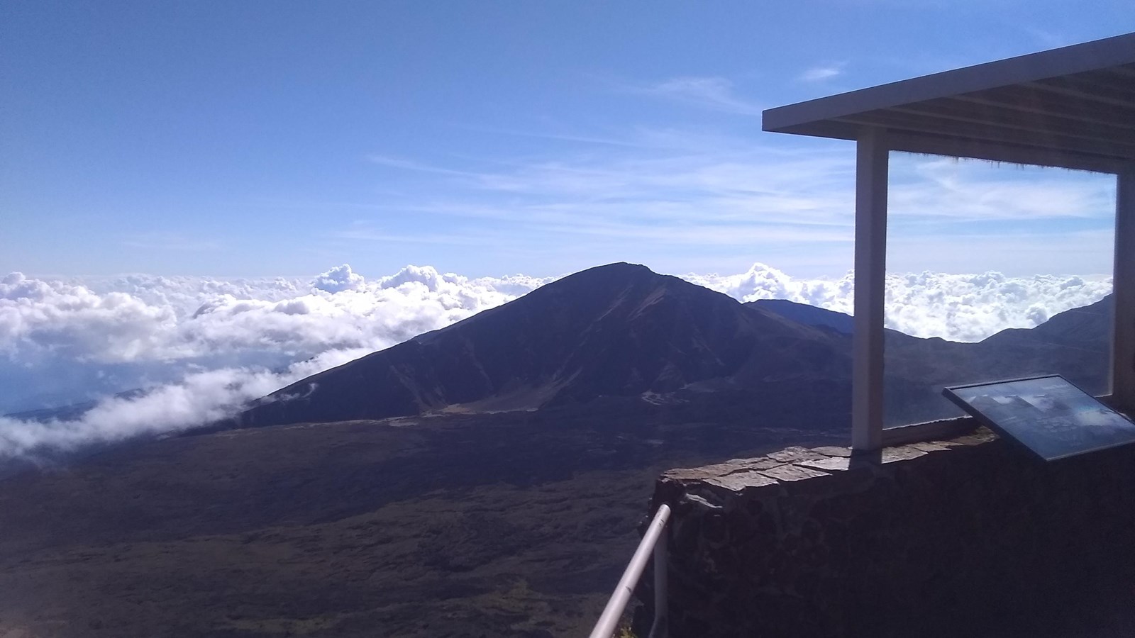 A small shelter looks over a green volcanic valley.