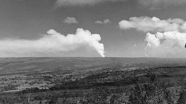 Volcano erupting along its flank in a distance. 