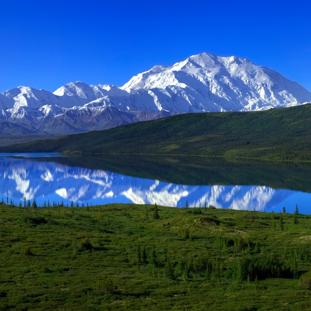 a range of snowy mountains leading up to one particularly huge peak