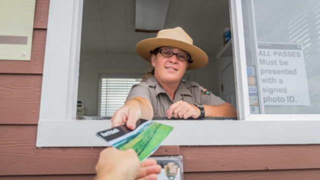 A park ranger hand out a park brochure