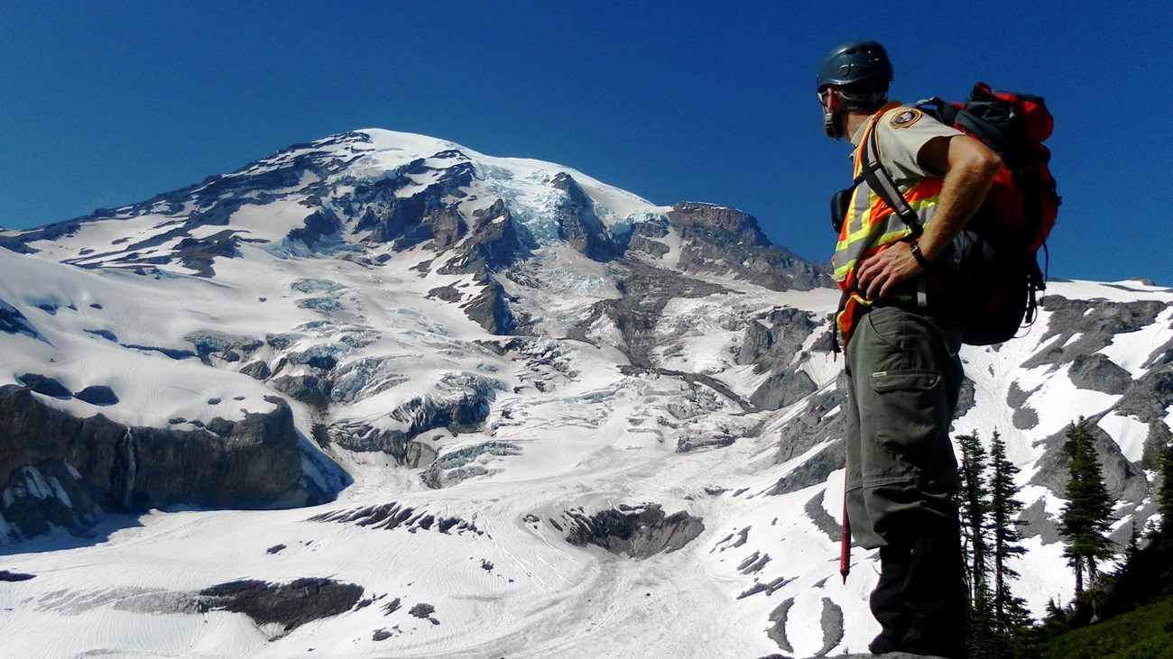 park ranger with glaciated peak in background