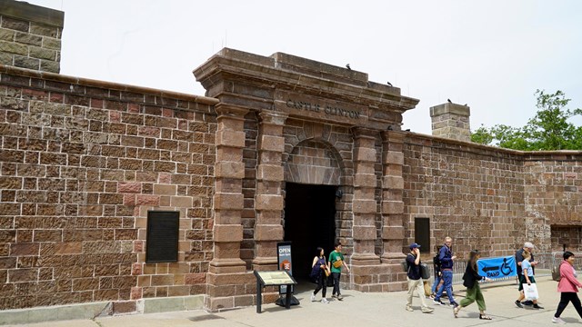 Visitors walk out of the main entrance to Castle Clinton 