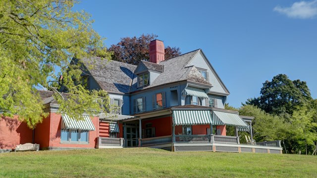 The Roosevelt home with blue sky and green grass.