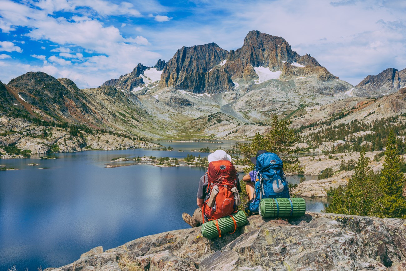 hikers enjoying view of alpine basin and mountain peaks