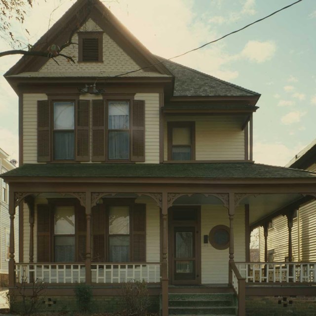 a color image of a home with a peaked roof and porch