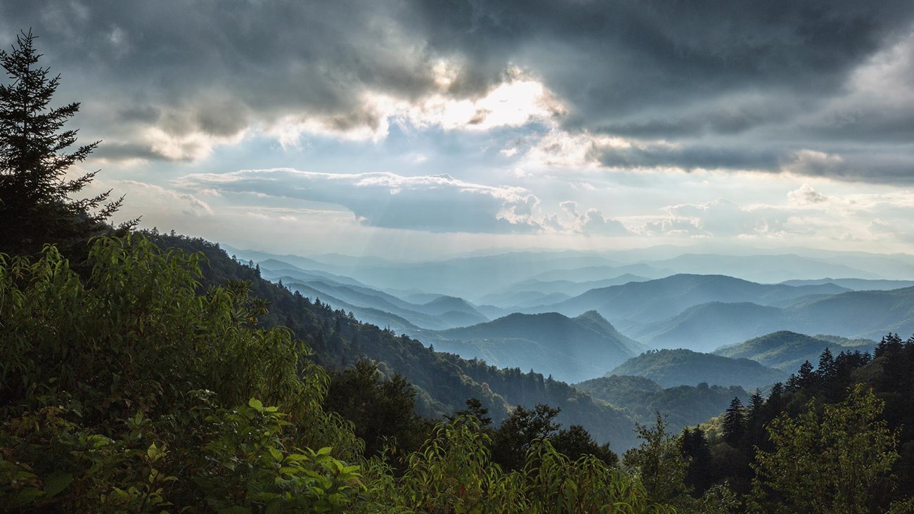 Storm clouds brood over mountains stretching to the horizon