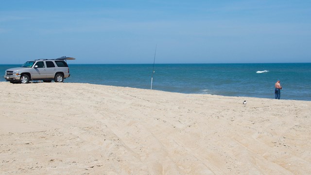 Fisherman on beach with ORV