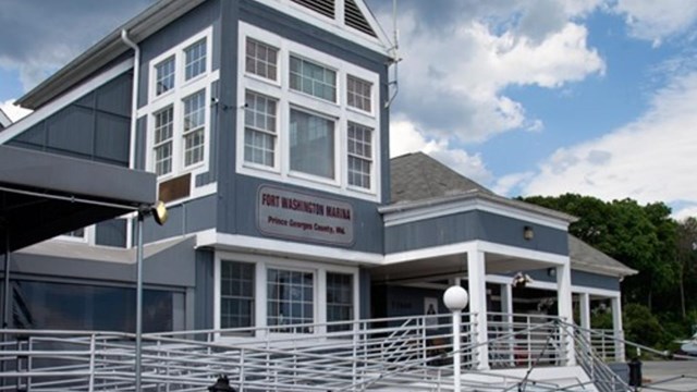 a grey and white building with a porch and some patio furniture 