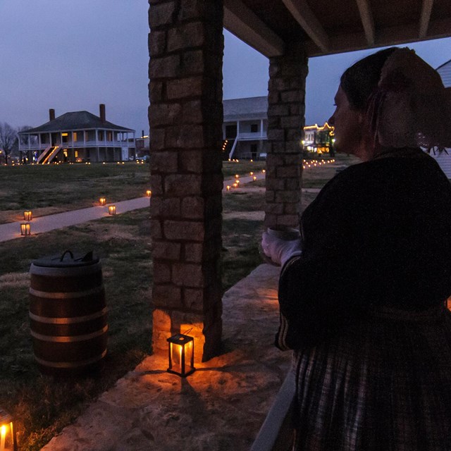 woman on right overlooks fort at night 