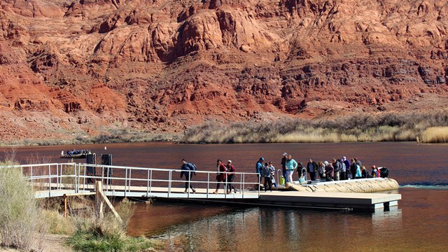 Customers file off of a large motorized raft at the Lees Ferry boat dock