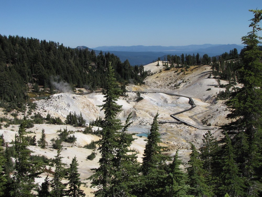 barren valley surrounded by forested hills