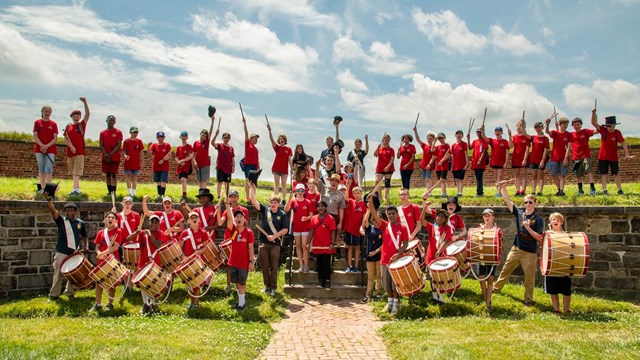 Student musicians posed along wall of fort.