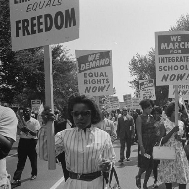 Women protesting holding signs. 