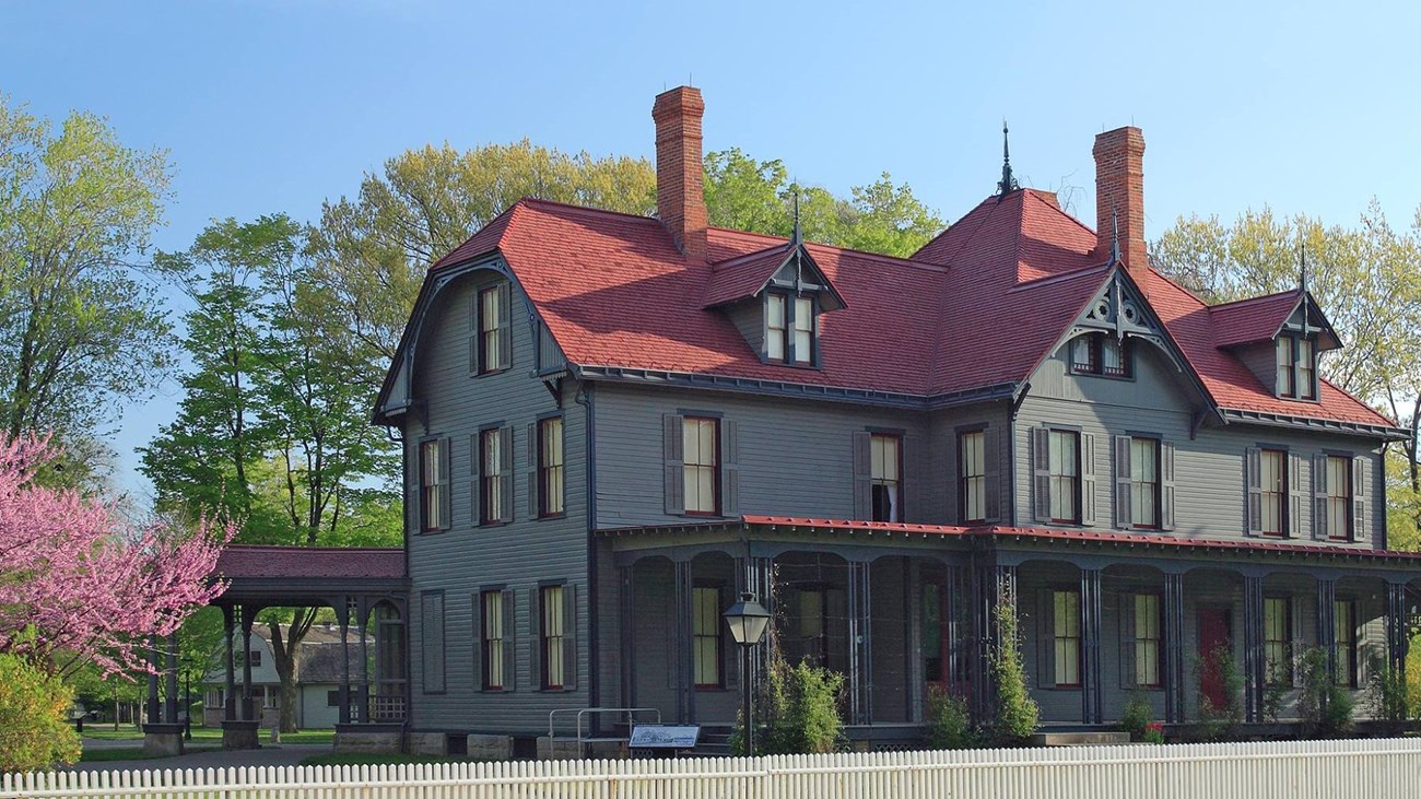 Front of Garfield house with blooming trees in background.