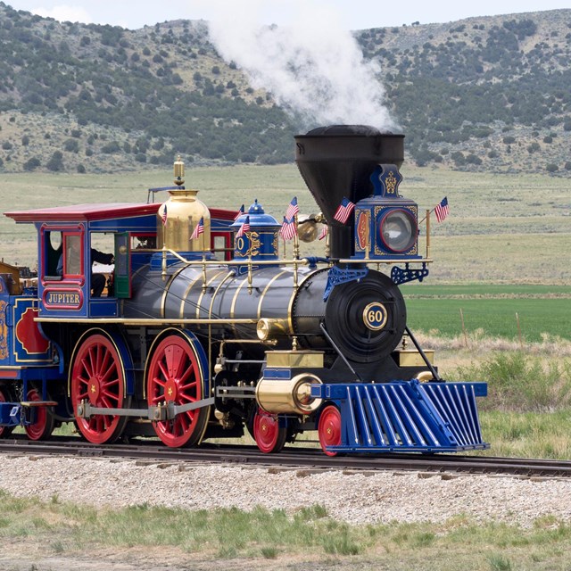 Historic blue, red, and black Jupiter train on the tracks. 