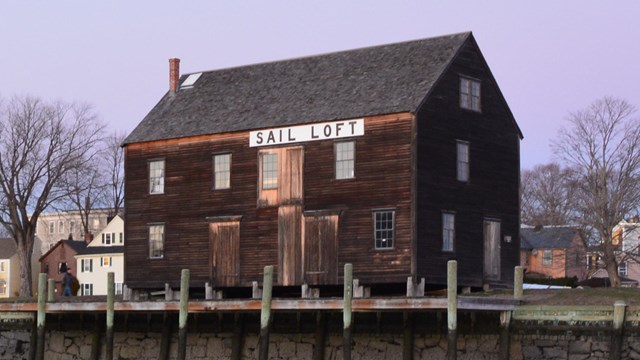 A three-story wooden building along a historic wharf
