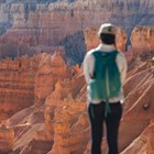 A visitor looks out over a landscape of red rock formations.