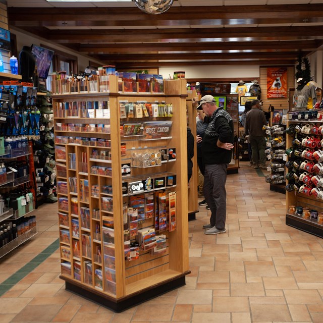 The interior of a store with product racks and people shopping.