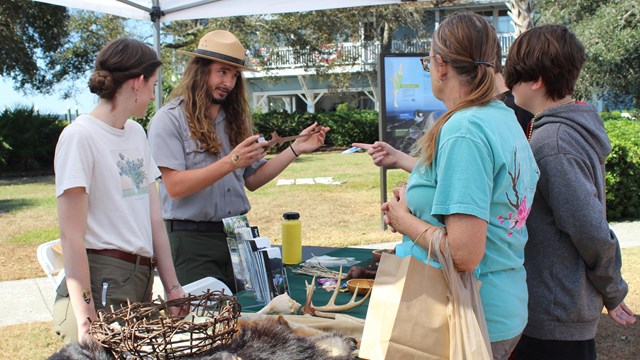 ranger at table talks to 3 visitors 