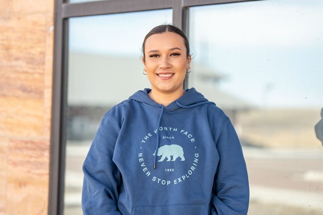 A woman smiling in front of a door