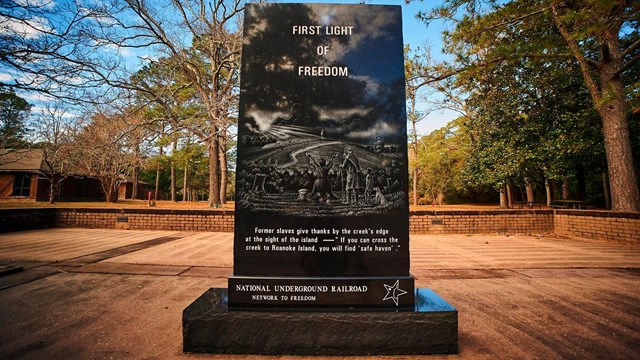 Granite monument reading "First Light of Freedom"