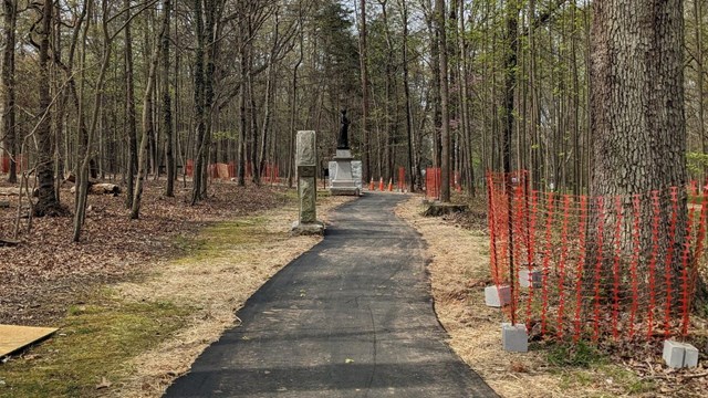 Paved path with trees and monuments alongside