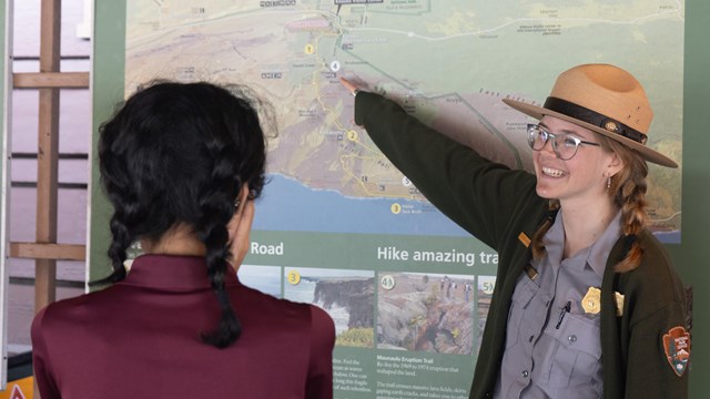 A ranger pointing at an orientation board. 