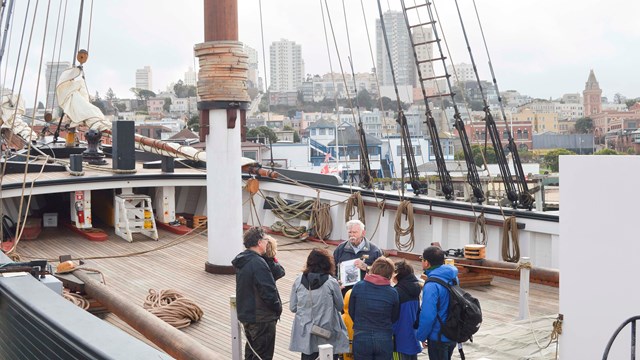 A sailing ship built in 1886 moored along a pier.