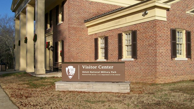 Brick building with large yellow columns. 