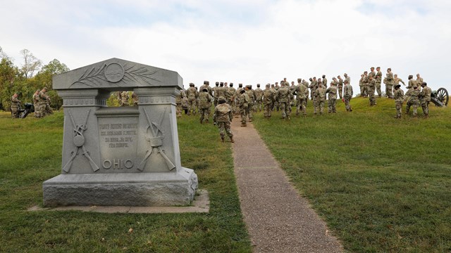 A park ranger discussing the military operations during the Vicksburg Campaign to seven soldiers.