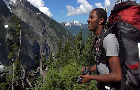 Hiker enjoys the wilderness views and prepares to take a photograph.