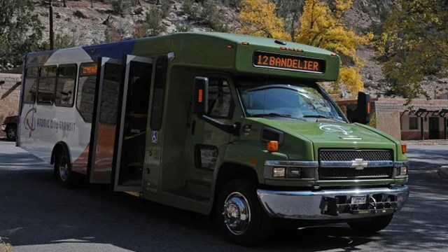 A green shuttle bus with Atomic City Transit written on the side.