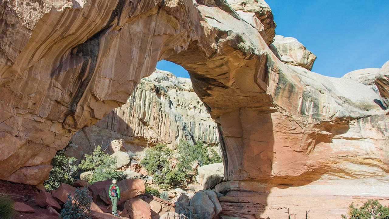 A hiker standing under Hickman Natural Bridge