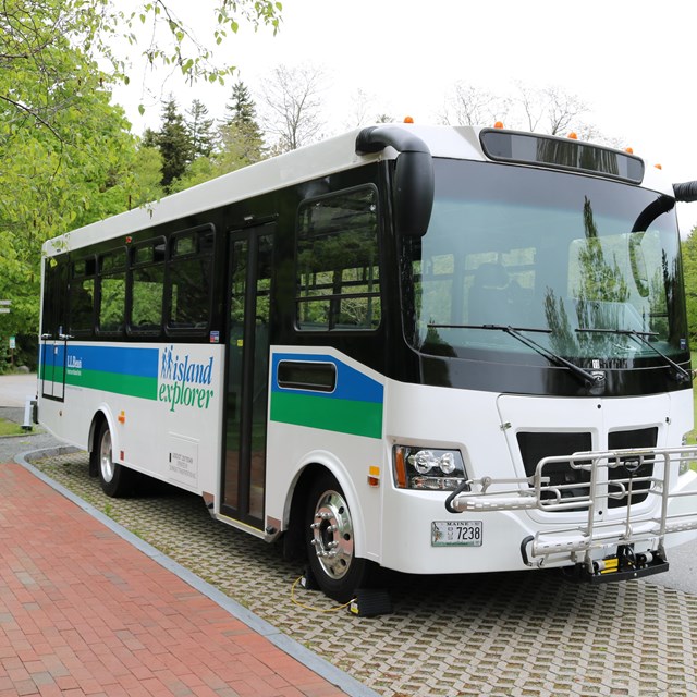 A large, rectangular bus parked at a curb.