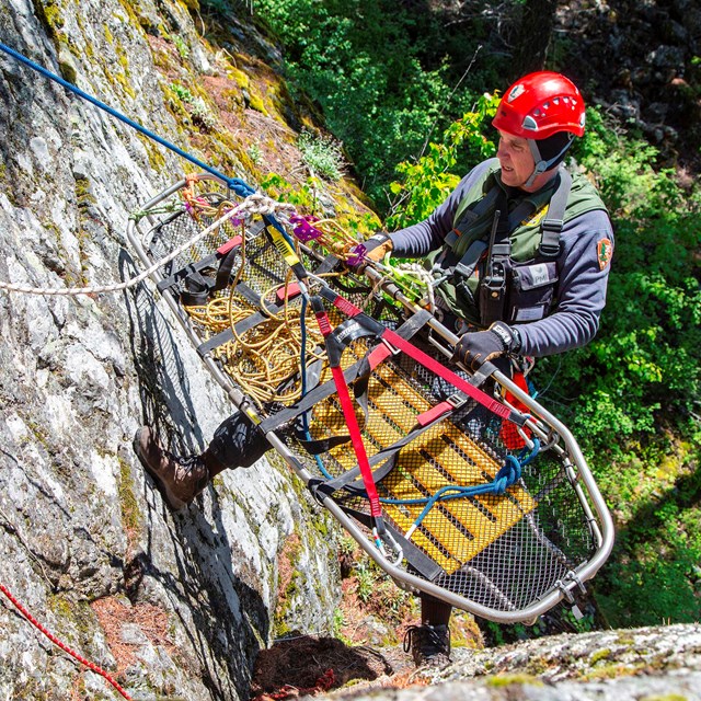 Park Ranger rapelling with a littler during rescue training.