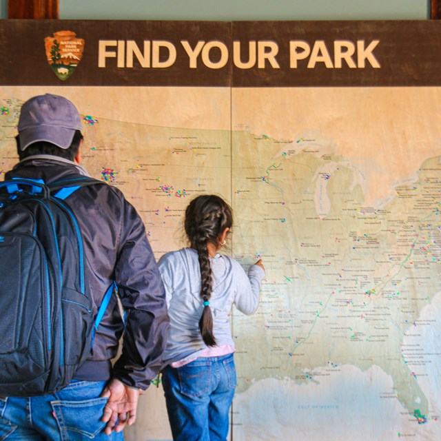 Two visitors looking at a large map of the U.S.