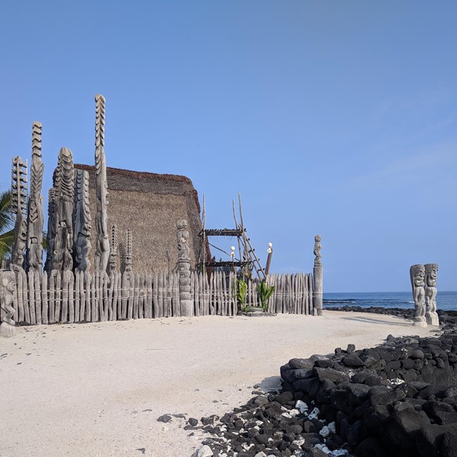 Hale o Keawe and accompanying kiʻi images on a clear day.