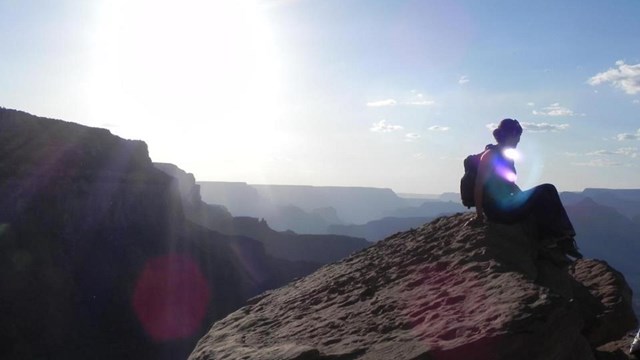 Woman sitting on a mountain. Photo by Dept of Interior, CC BY-SA 2.0 