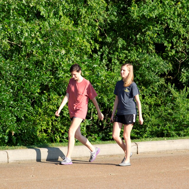 2 women walk the park tour road