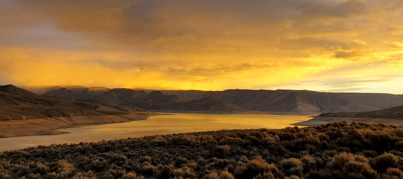 Yellow and orange sunset sky over a reservoir