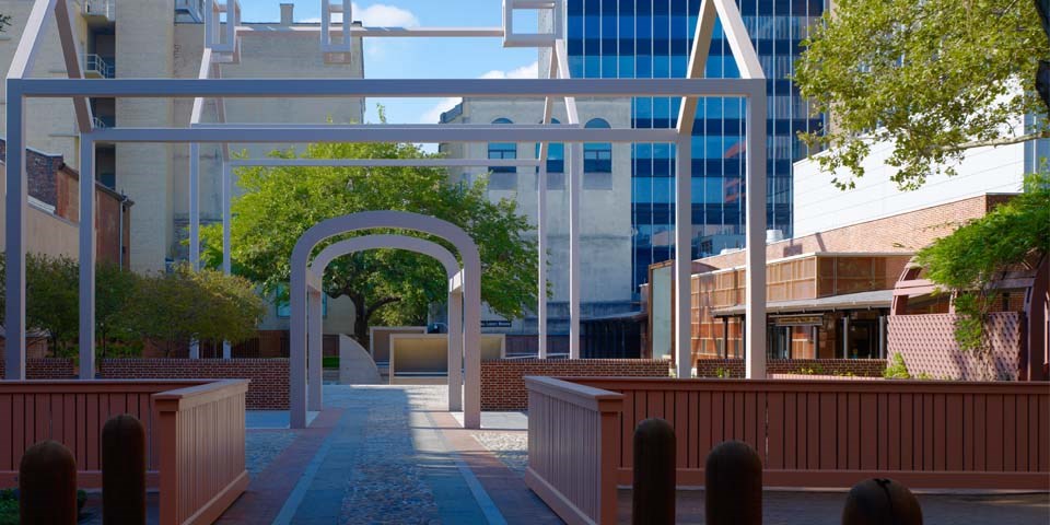 Color photo of the Franklin Court courtyard showing white steel frames in the shape of houses.