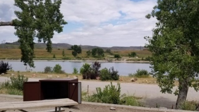 An empty campsite at afterbay looks out into the water.