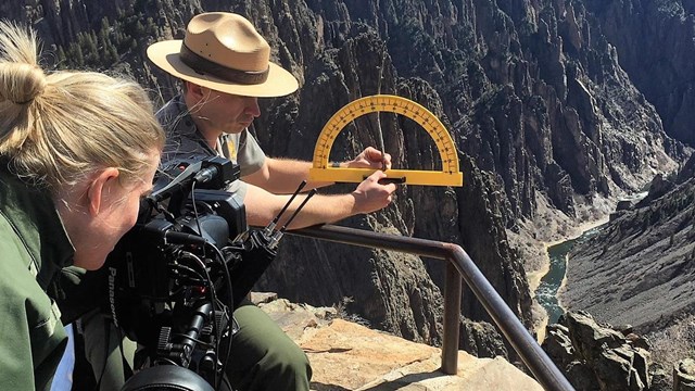 A videographer films a ranger presenting an educational program