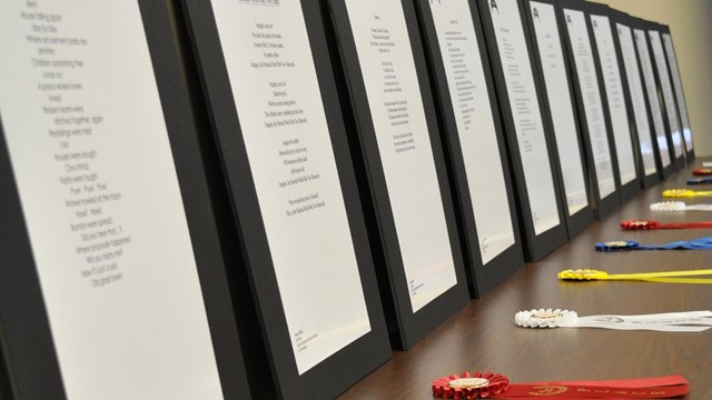 Ribbons and poems are displayed for student recognition.