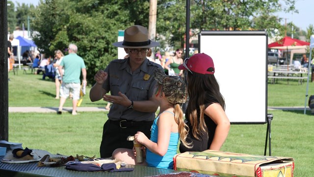 Ranger showing two children an artifact