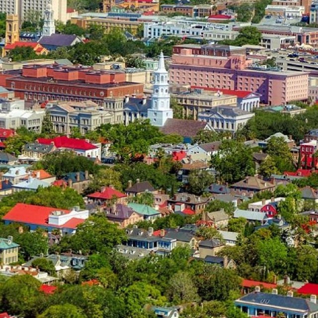 Ariel photo of city of Charleston surrounded by the ocean. 