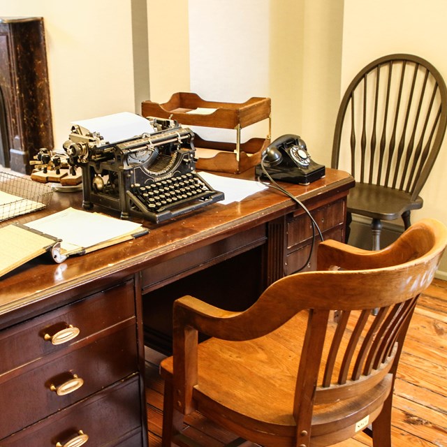 Desk covered with papers and a typewriter