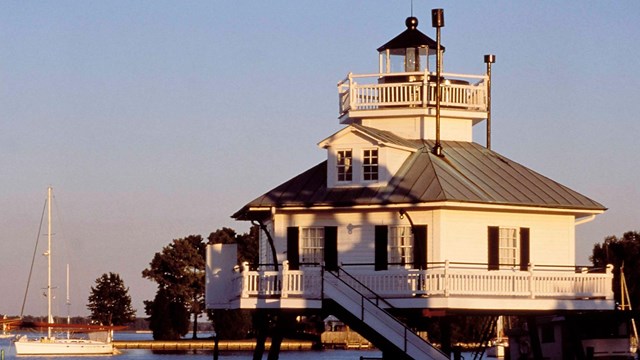 Picture of a white elevated building overlooking the water