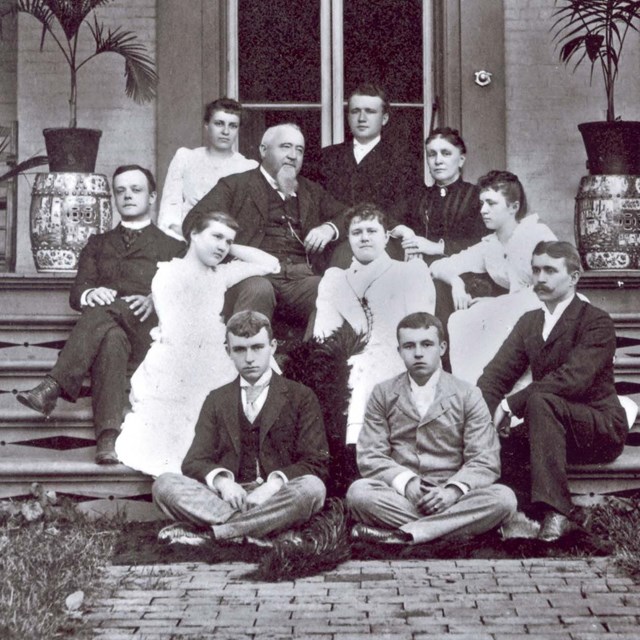 The Gambrill family seated on the steps of their home.