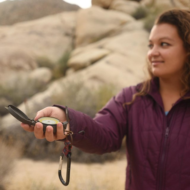 Visitor holding a compass in the desert